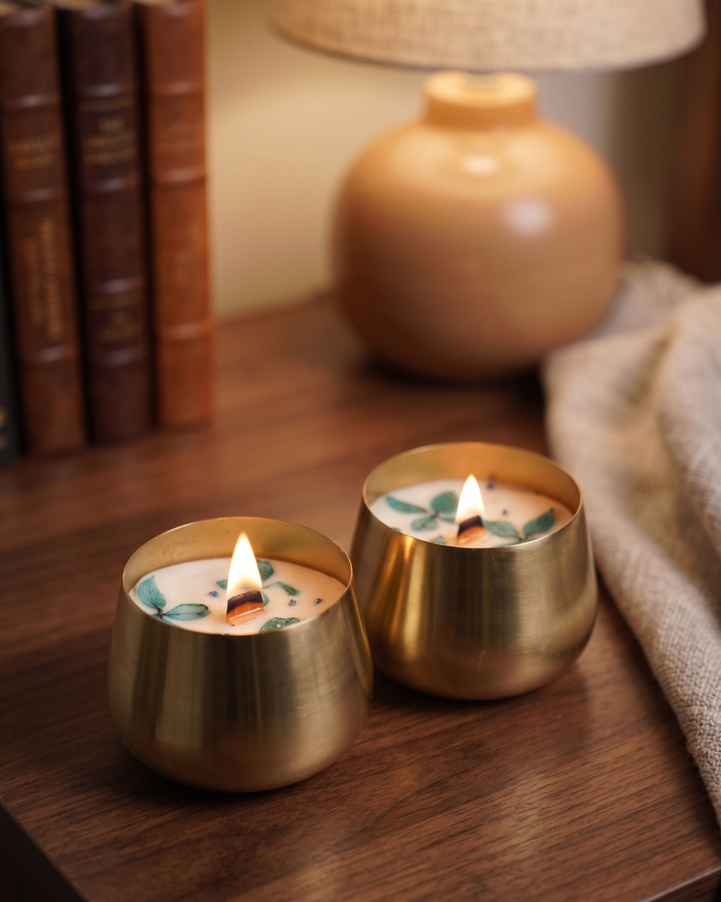 Fragnam Golden Glow Urli Candle in a decorative gold-colored vessel with a lit flame, creating a warm and cozy ambiance.