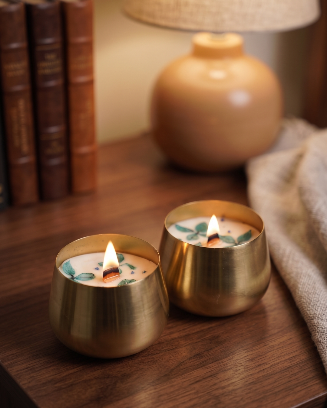 Fragnam Golden Glow Urli Candle in a decorative gold-colored vessel with a lit flame, creating a warm and cozy ambiance.