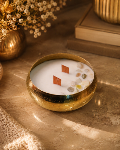 Fragnam Swarna Aura Candle with golden decorative design and elegant glass holder, showcasing a warm, inviting glow.