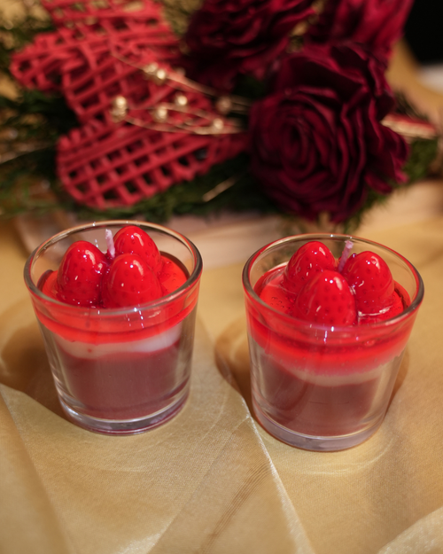 Fragnam Strawberry Charm Candle featuring a pink wax candle with a small strawberry-shaped charm on top.